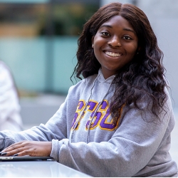 African American women smiling wearing SFSU sweatshirt