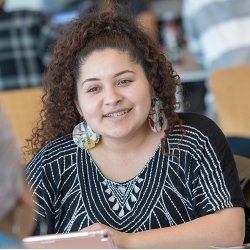 SF State student smiling inside the SF State library